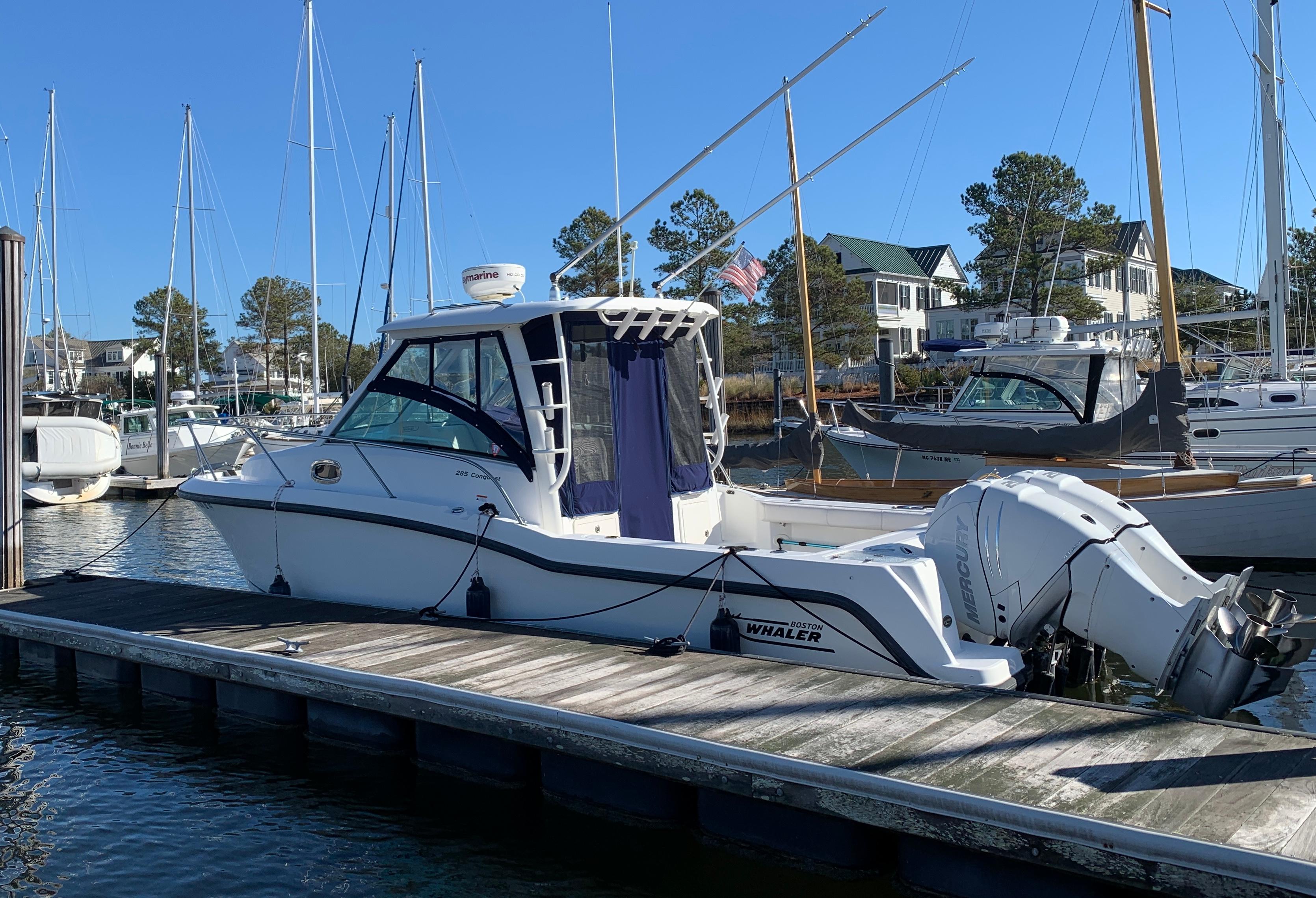 Boston Whaler 285 Conquest 2012 Boston Whaler 285 Conquest docked at a marina with sailboats in the background.