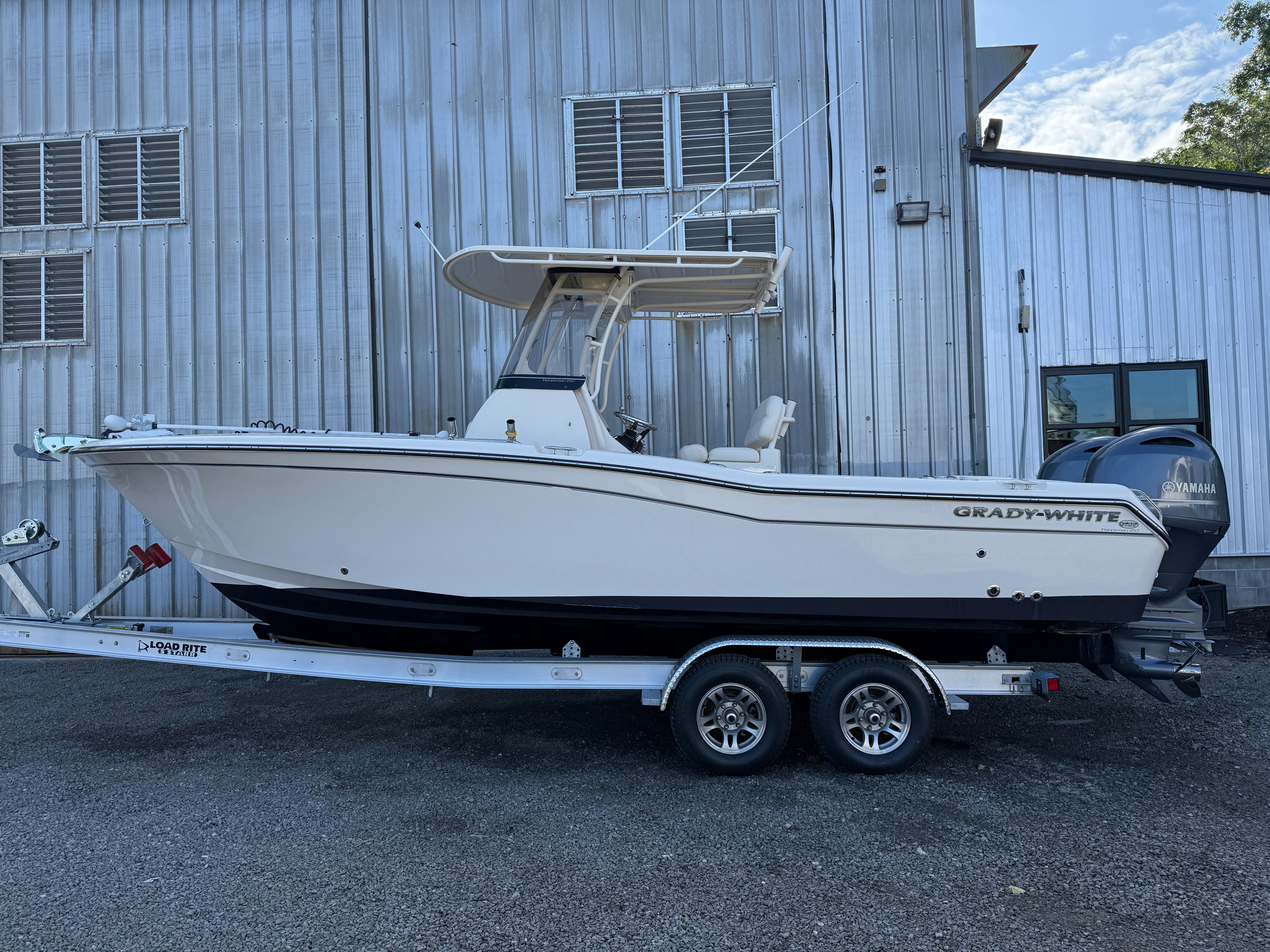 Grady-White Fisherman 257 2020 Grady-White Fisherman 257 boat on trailer, parked beside a metal building.