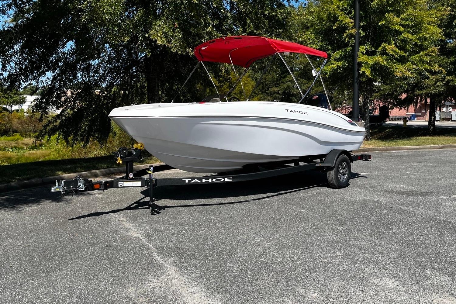 Tahoe T18 2026 Tahoe T18 boat with red canopy on trailer, parked outdoors.