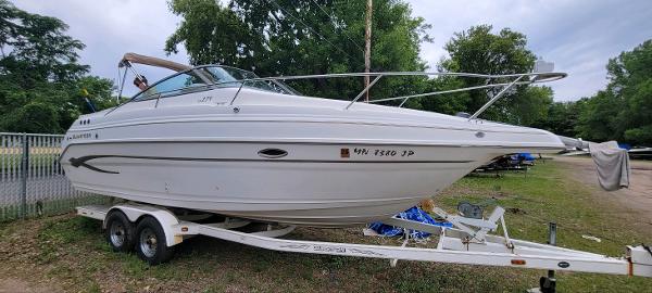 Glastron GS 279 2002 Glastron GS 279 boat on trailer, parked outdoors, side view.