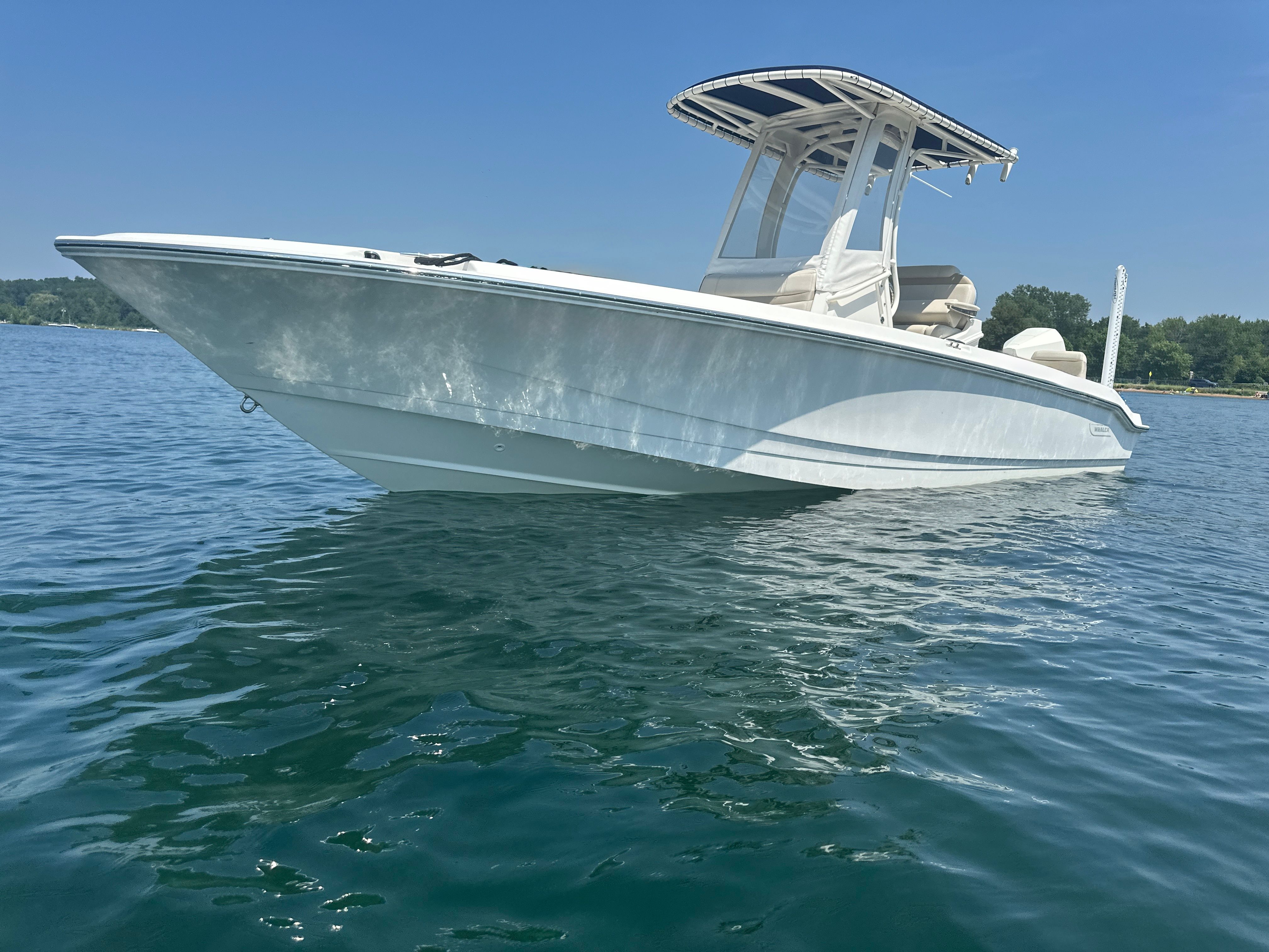 Boston Whaler Dauntless 250 2022 Boston Whaler Dauntless 250 boat on calm blue water.