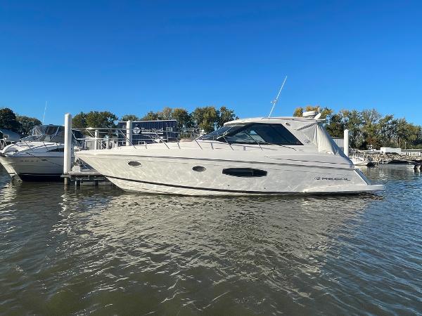 Regal 42 Sport Coupe 2015 Regal 42 Sport Coupe yacht docked on calm water under clear blue sky.