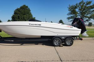 Tahoe T21 2026 Tahoe T21 boat on trailer, parked outdoors, with trees in the background.