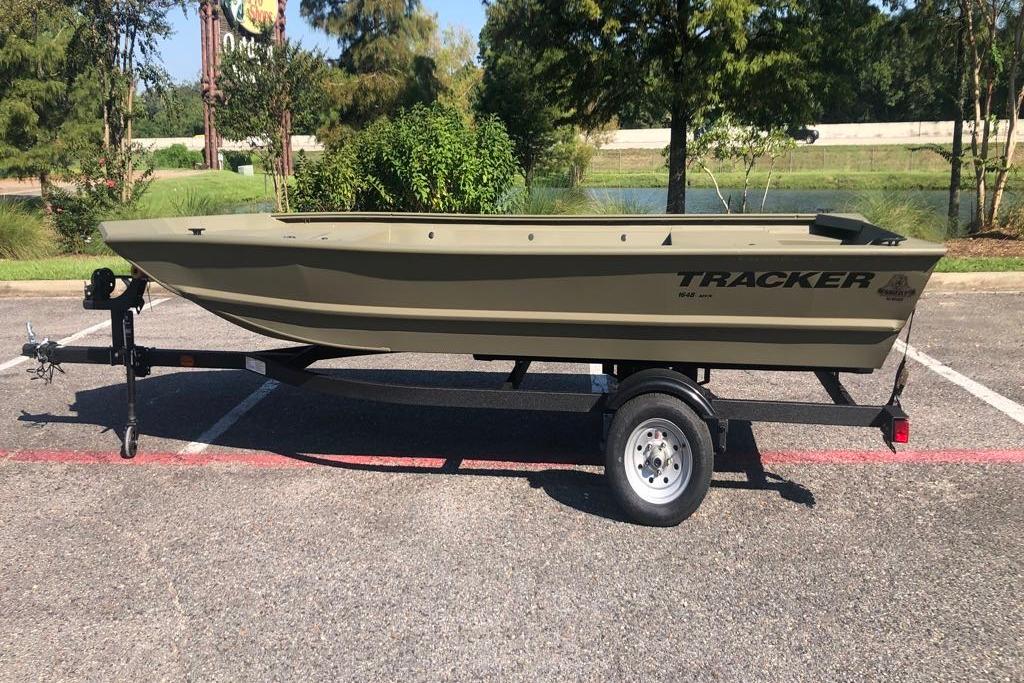Tracker Grizzly 1648 Utility 2026 Tracker Grizzly 1648 Utility boat on trailer in parking lot.