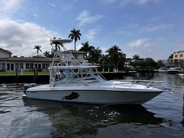 Contender 35 Side Console 2006 Contender 35 Side Console boat on a calm waterway with palm trees in the background.