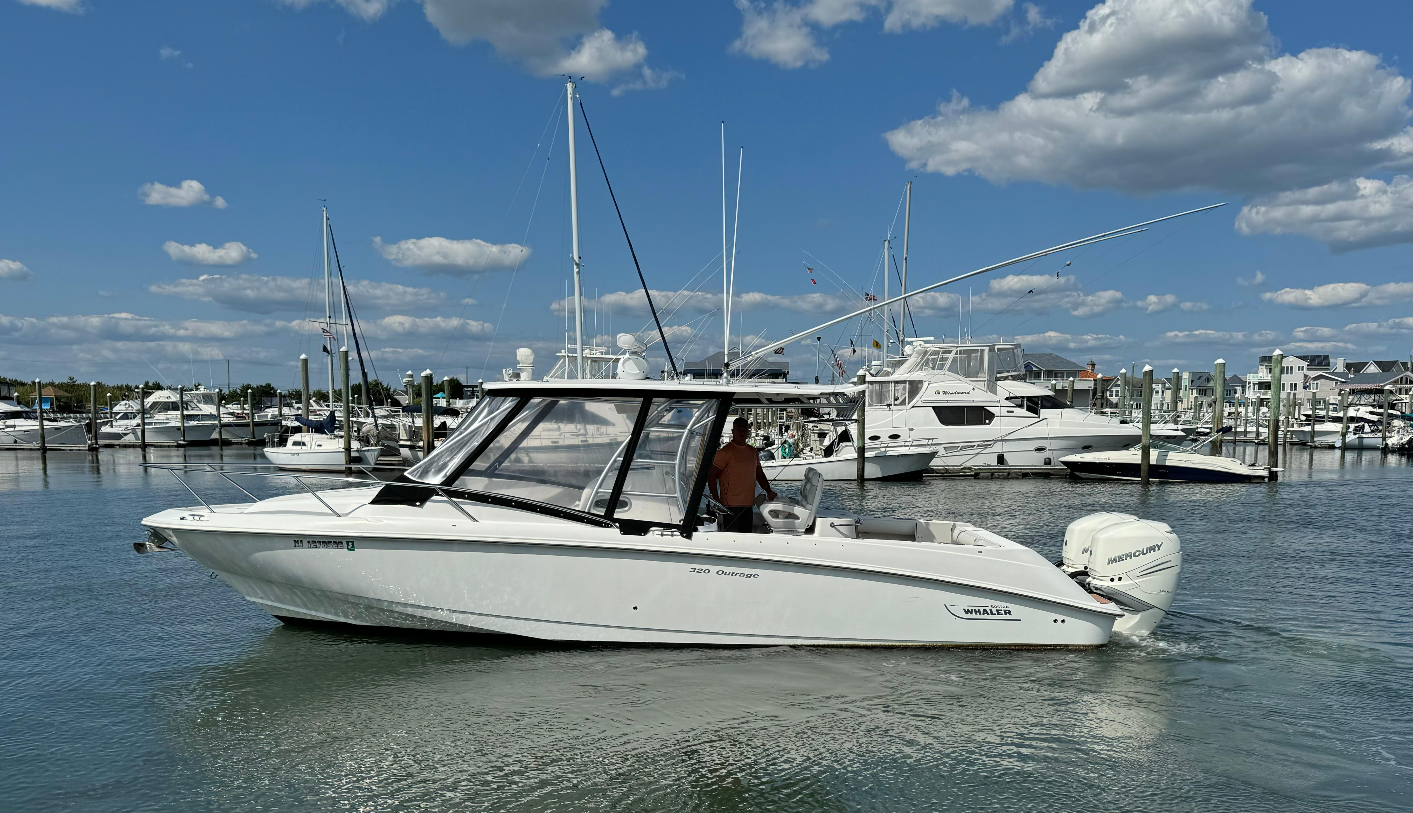 Boston Whaler 32 Outrage Cuddy 2006 Boston Whaler 32 Outrage Cuddy boat in marina under blue sky.