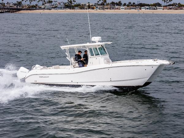 World Cat 325 CC 2024 World Cat 325 CC cruising on open water near a sandy shoreline.