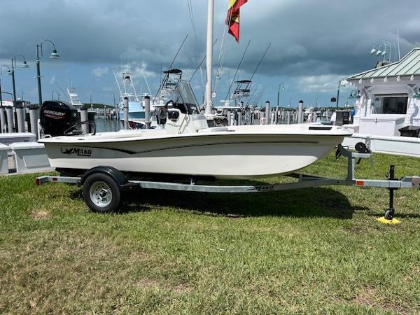 Mako Pro Skiff 15 CC 2025 Mako Pro Skiff 15 CC boat on trailer at marina, cloudy sky background.