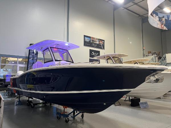 Scout 277 LXF 2025 Scout 277 LXF boat displayed indoors with blue hull and illuminated canopy.