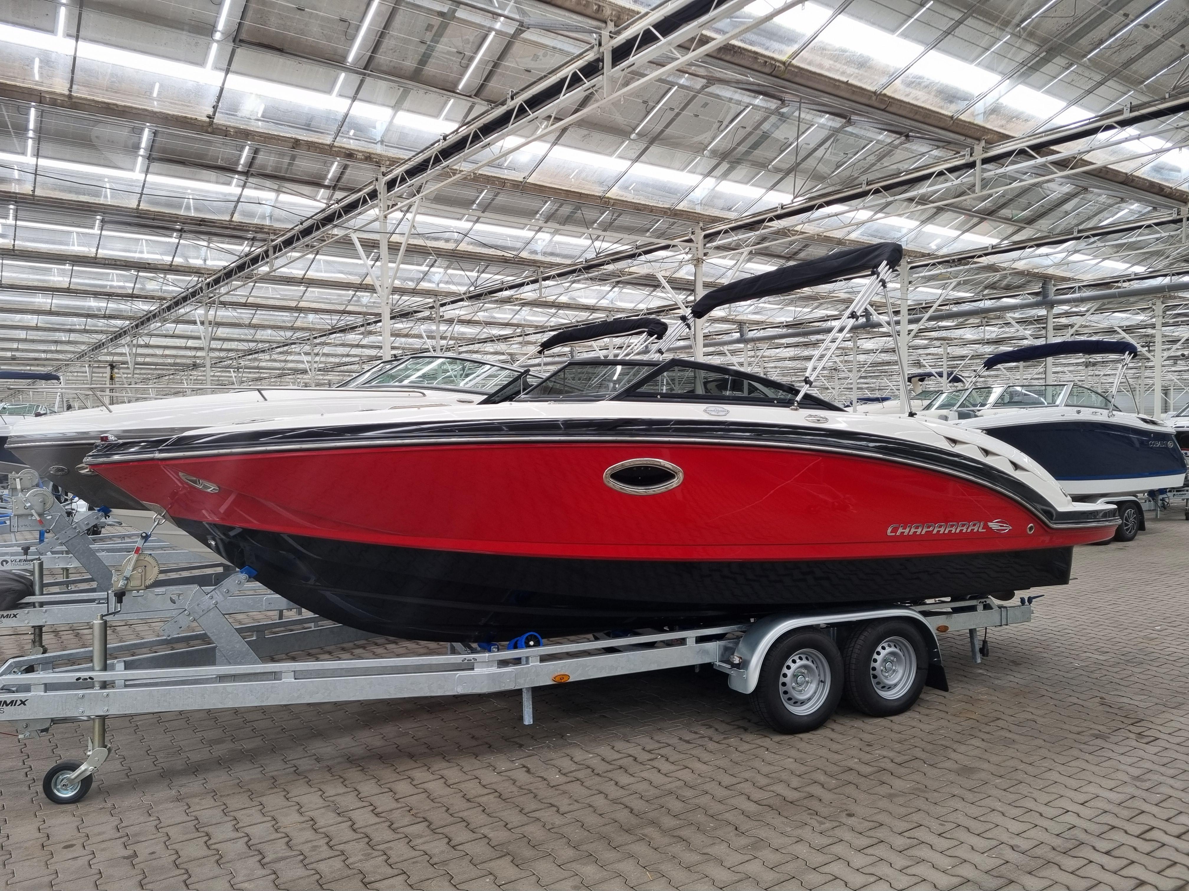 Chaparral 224 Widetech 2009 Chaparral 224 Wide Tech boat with red hull on trailer in warehouse.