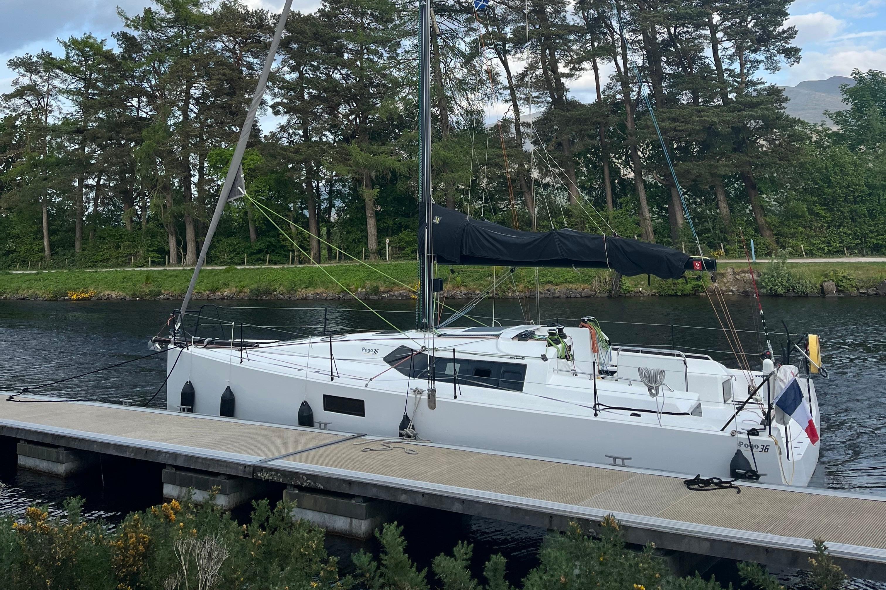 Pogo pogo 36 2021 Structures POGO 36 sailboat docked by a scenic, tree-lined waterway.