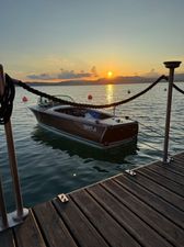Riva Florida Vintage 1964 Riva Florida boat docked at sunset on a serene lake.