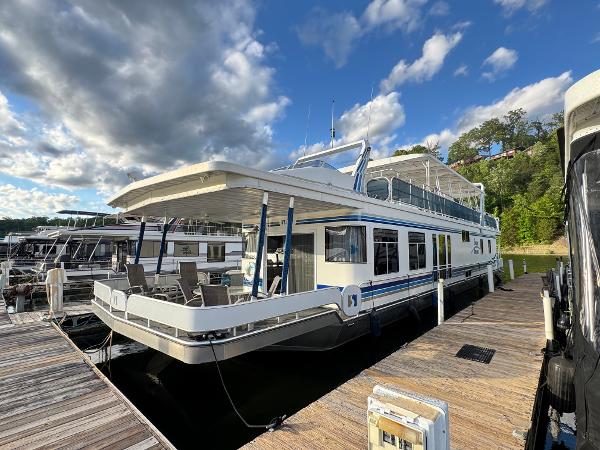 Sharpe 18x89 Houseboat docked under cloudy sky, Sharpe 18x89 model, 2006, with outdoor seating area.