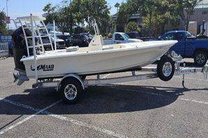 Mako 18 Pro Skiff 2026 Mako Pro Skiff 18 boat on trailer in parking lot, sunny day.