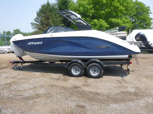 Yamaha Boats AR220 2025 Yamaha Boats AR220 on trailer, blue and white design, parked outdoors.