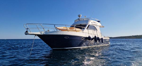Custom Sagene 40 fly Custom Sagene 40 Fly yacht, 2004 model, cruising on open water under clear blue sky.