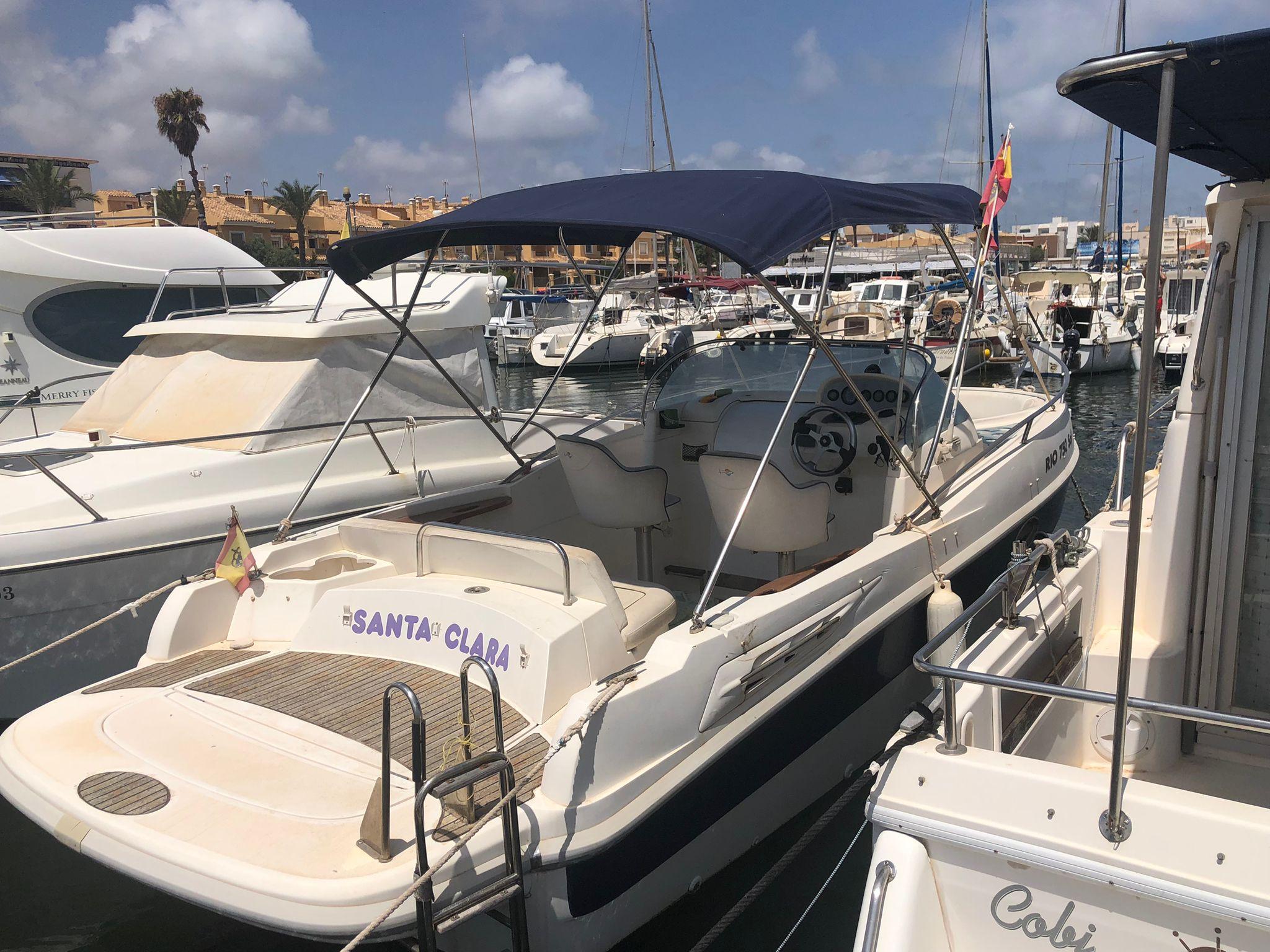 RIO 750 Sol 2004 RIO 750 Sol boat docked in a marina, featuring a canopy and spacious deck.