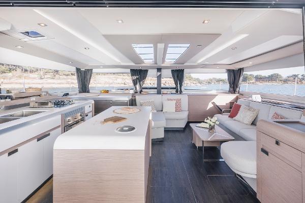 Fountaine Pajot Aura 51 Luxurious interior of 2025 Fountaine Pajot Aura 51 catamaran with modern kitchen and spacious seating area.