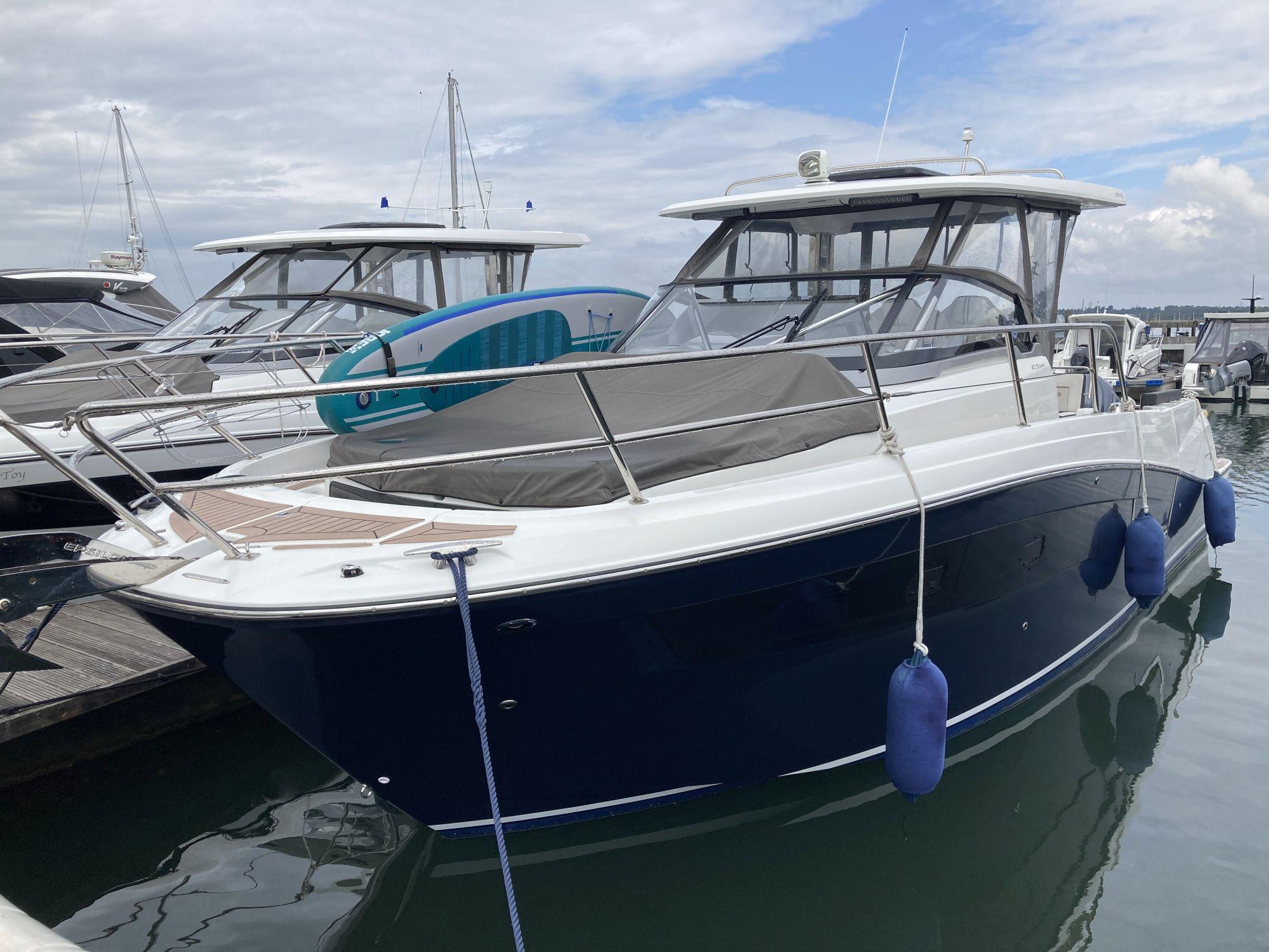 Jeanneau Cap Camarat 10.5WA 2023 Jeanneau Cap Camarat 10.5WA boat docked with blue fenders and paddleboard.