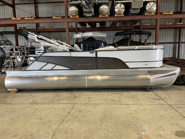 Crest 220 SLSC Classic DLX 2024 Crest 220 SLSC Classic DLX pontoon boat in a storage facility.
