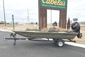 Tracker Grizzly 1648 SC 2025 Tracker Grizzly 1648 SC boat on trailer near Cabela's sign.