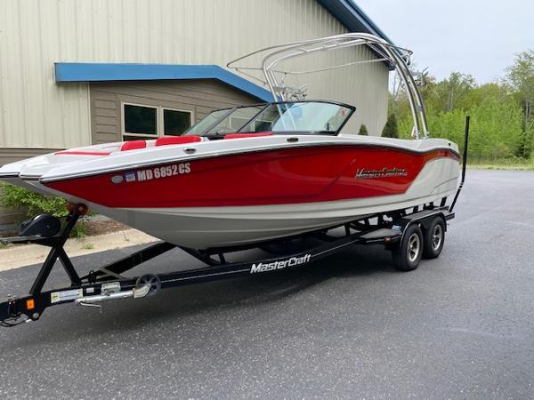 MasterCraft NXT22 2017 MasterCraft NXT22 boat in red and white on a trailer, parked outdoors.