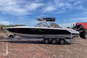 Donzi DAYTONA 35 ZF CUDDY 2005 Donzi Daytona 35 ZF Cuddy boat on trailer, parked on brick pavement.