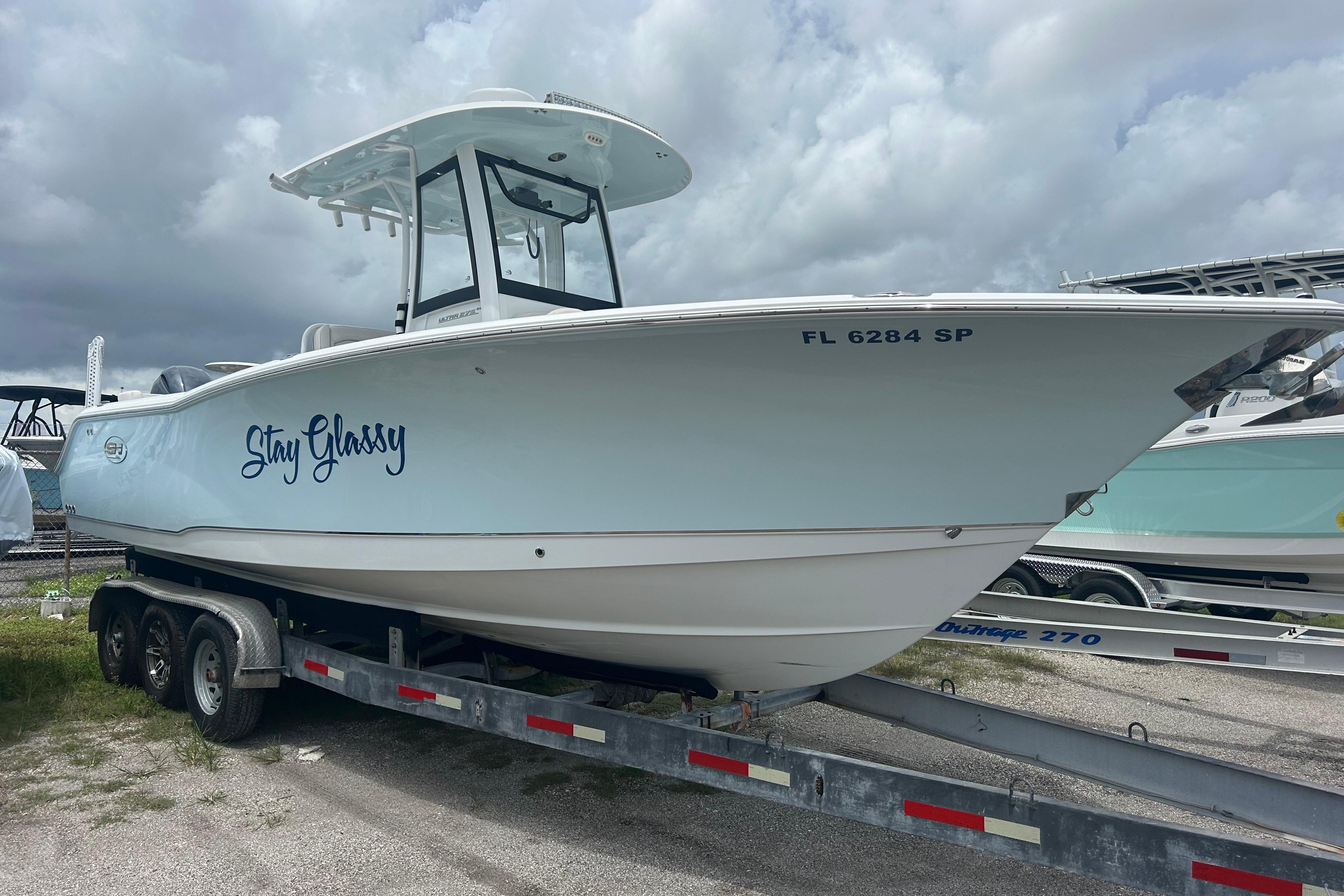 Sea Hunt Ultra 275 SE 2020 Sea Hunt Ultra 275 SE boat on trailer, named "Stay Glassy," under cloudy sky.