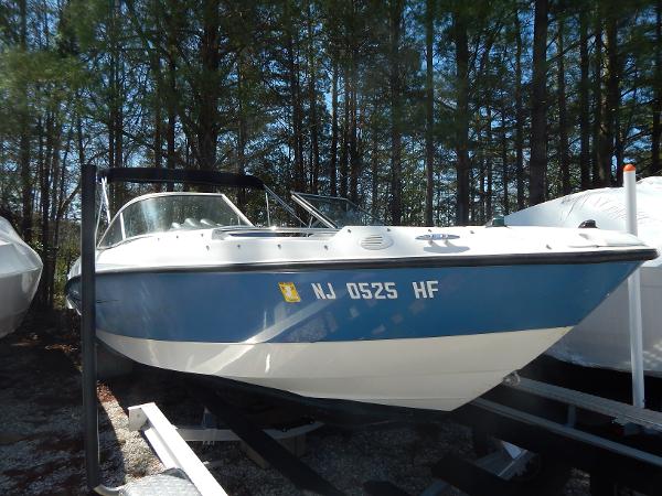 Bayliner 235 Bowrider 2013 Bayliner 235 Bowrider boat on trailer, parked in wooded area.