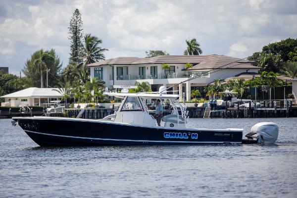 Regulator 41 2021 Regulator 41 boat cruising on a calm waterfront near luxury homes.