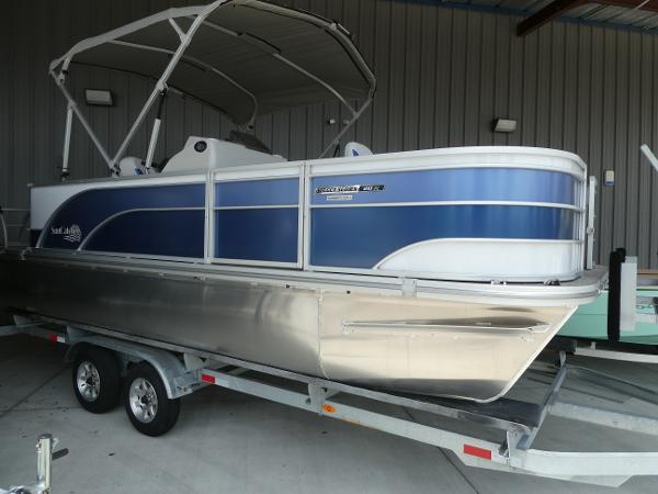 SunCatcher Select 20FC 2023 SunCatcher Select 20FC pontoon boat on a trailer in a storage facility.
