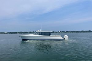 MJM 4 2024 MJM 4 boat cruising on calm waters under a clear sky.