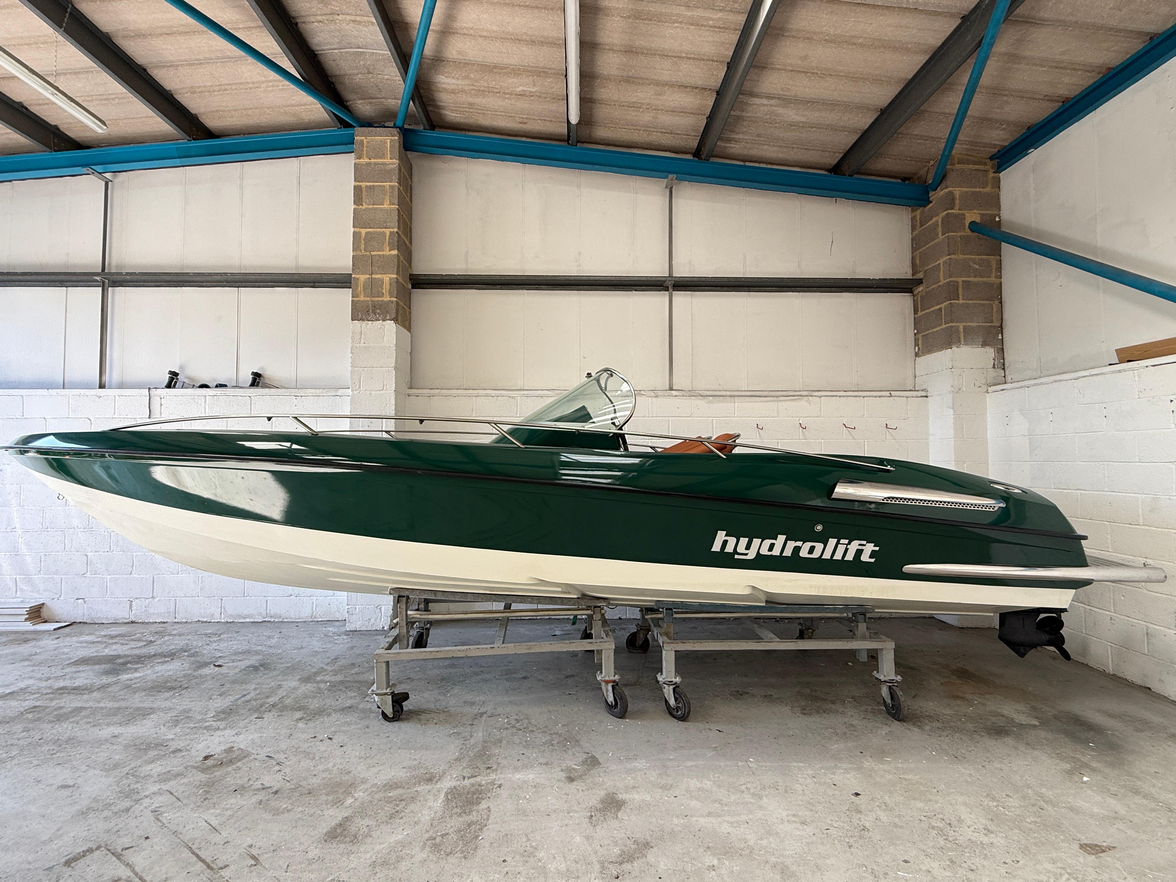 Hydrolift S24 2002 Hydrolift S24 boat in a garage, green and white design, side view.