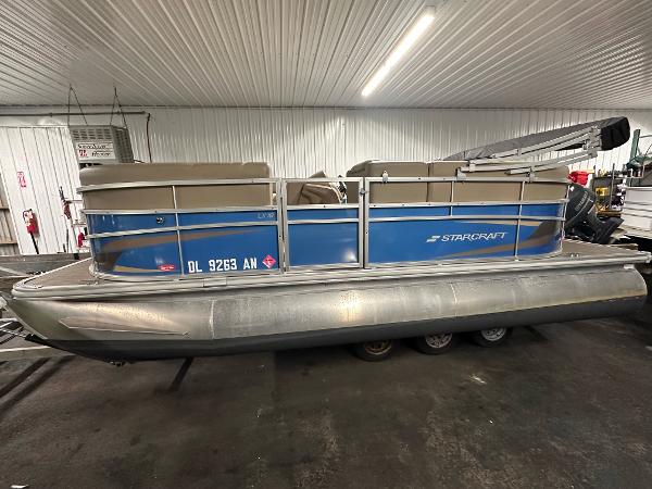 Starcraft LX 18 R 2022 Starcraft LX 18 R pontoon boat in a garage setting.