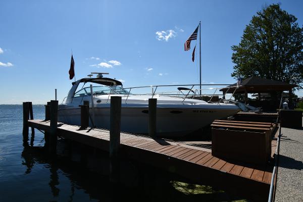 Sea Ray 400 Sundancer 1997 Sea Ray 400 Sundancer docked by a wooden pier under a clear blue sky.