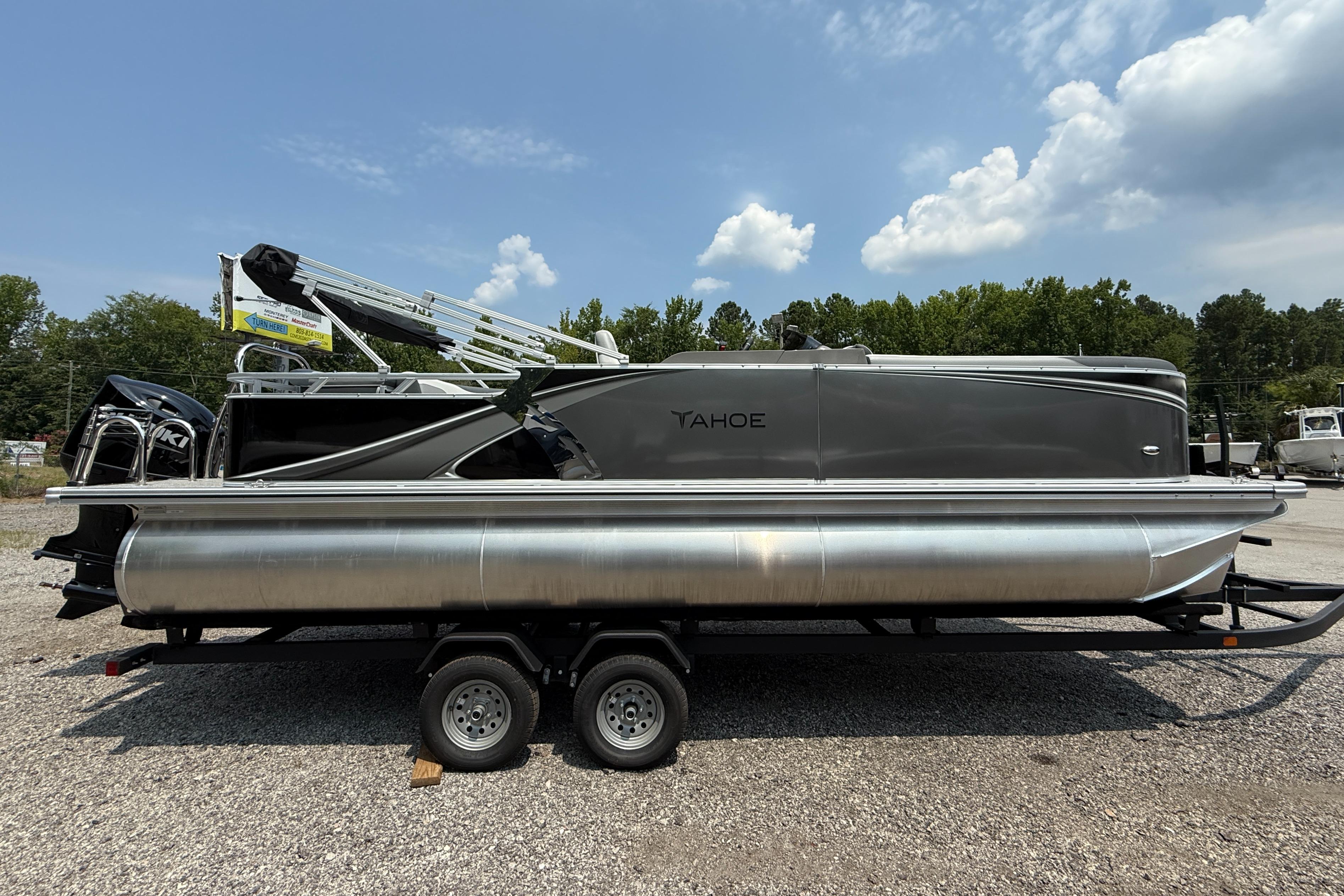 Tahoe Pontoon LTZ Cruise 2025 Tahoe Pontoon LTZ Cruise on trailer, parked outdoors under a partly cloudy sky.