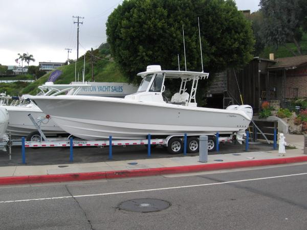 Edgewater 325 CC 2024 Edgewater 325 CC boat on a trailer at a yacht sales lot.