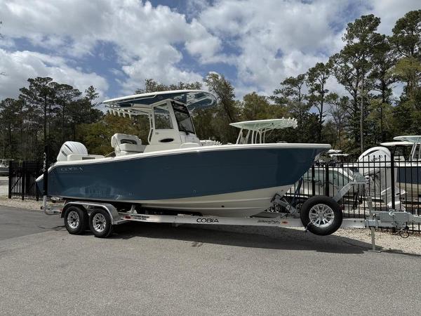 Cobia 240 Center Console 2025 Cobia 240 Center Console boat on trailer, parked outdoors under cloudy sky.