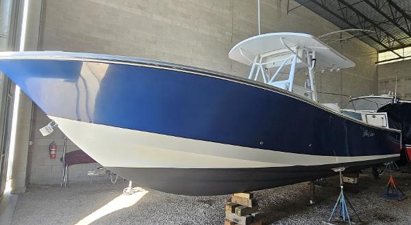 Regulator 32 Fs 2004 Regulator 32FS boat in storage, blue and white hull, elevated on stands.