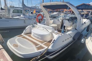 RIO 850 DAY CRUISER 2004 RIO 850 Day Cruiser docked at marina, featuring spacious deck and seating.