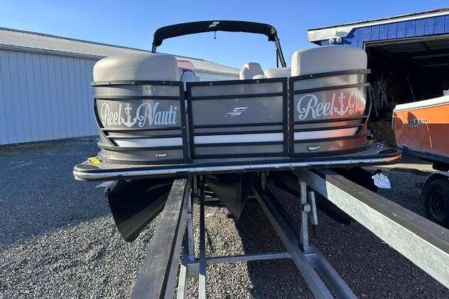 Starcraft SLS 1 2021 Starcraft SLS 1 pontoon boat on trailer, labeled "Reel Nauti," in storage area.