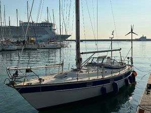Hallberg-Rassy 352 1980 Hallberg-Rassy 352 sailboat docked in marina with cruise ship in background.
