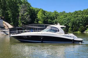 Sea Ray 44 Sundancer 2008 Sea Ray 440 Sundancer yacht on a serene lake with lush green trees.