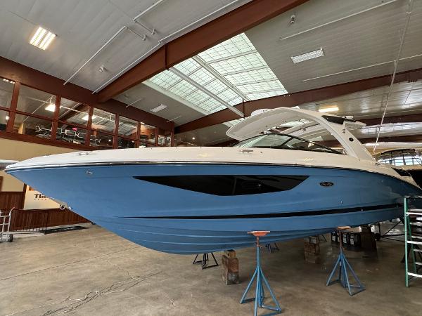 Sea Ray SLX 350 2025 Sea Ray SLX 350 boat in indoor storage, blue hull, elevated on stands.