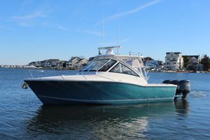 Albemarle 30 Express 2022 Albemarle 30 Express boat on calm water near coastal homes.