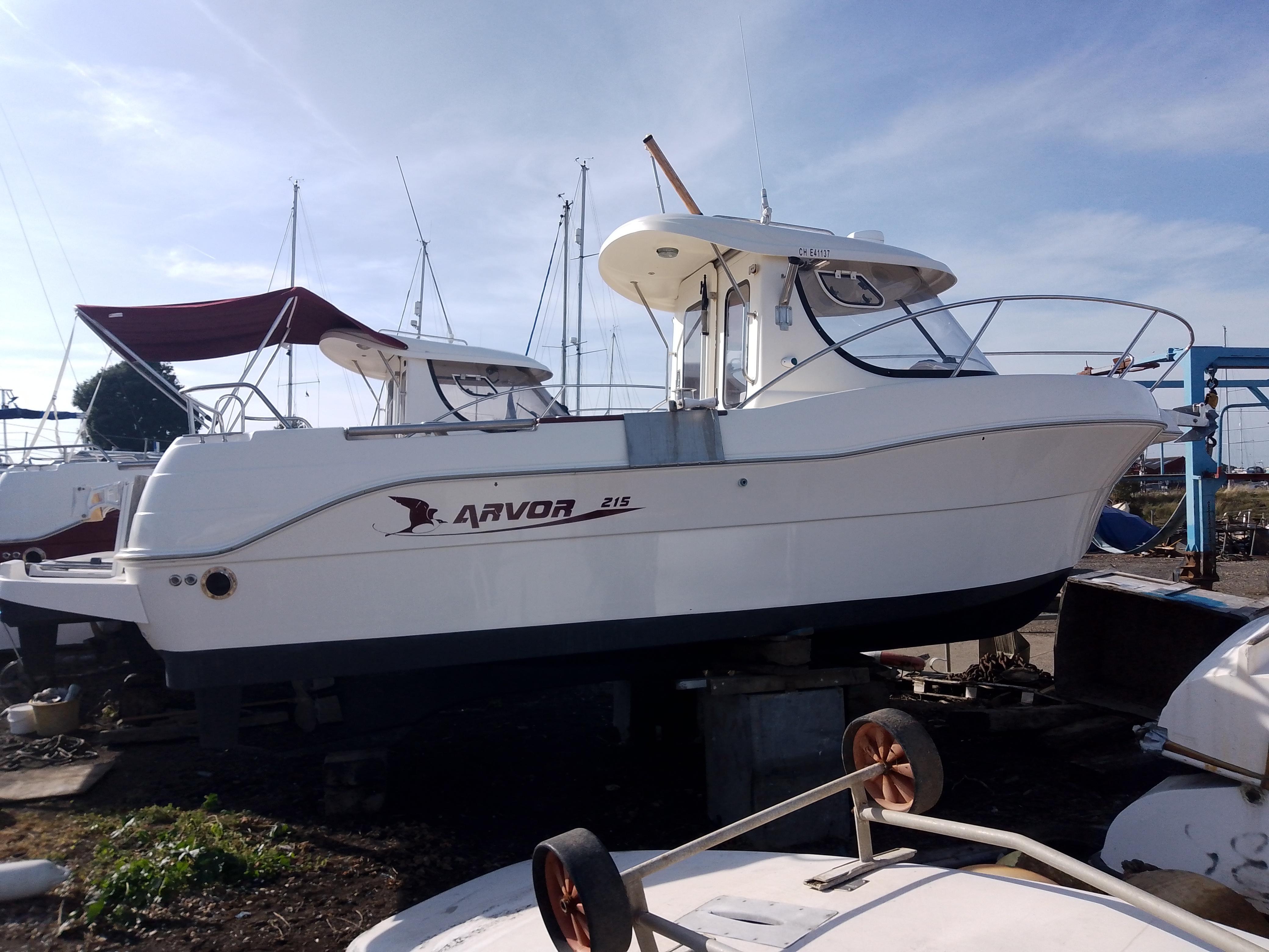 Arvor 215 2011 Arvor 215 boat on dry dock, white hull, marina background, clear sky.