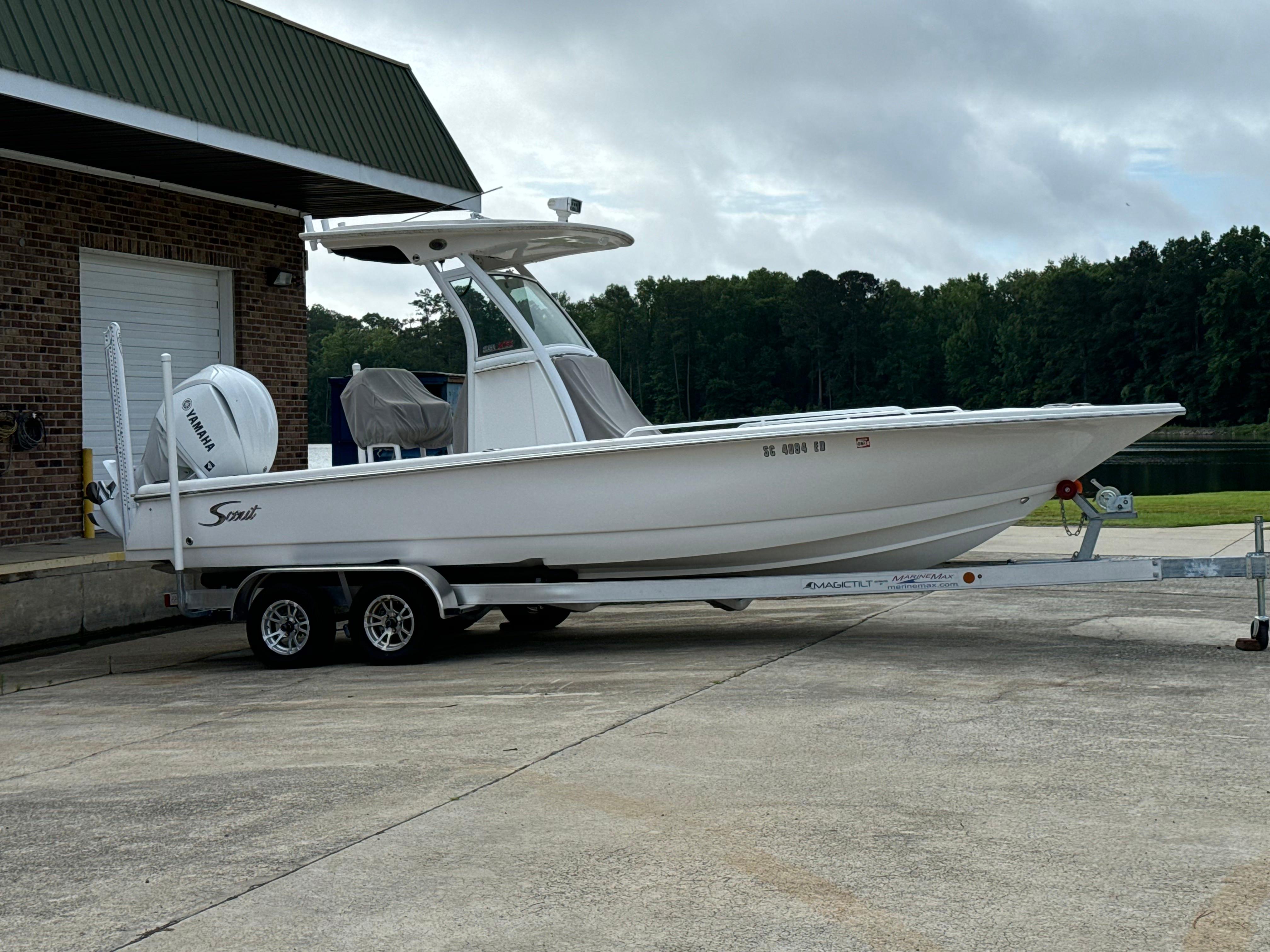 Scout 251 XSS 2022 Scout 251 XSS boat on trailer, parked near a building with trees in the background.