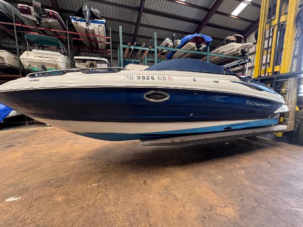Crownline 245 SS 2011 Crownline 245 SS boat in storage, blue and white hull, indoor facility.