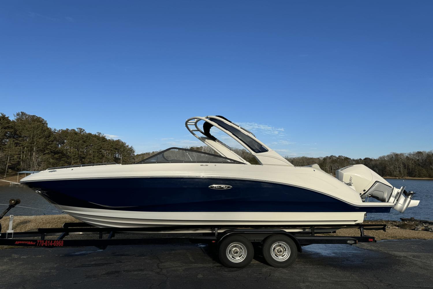 Sea Ray SDX 250 Outboard 2024 Sea Ray SDX 250 Outboard boat on trailer by a lake.