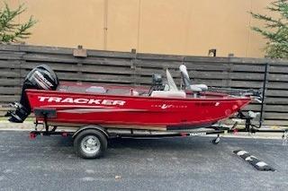 Tracker Pro Guide V-16 SC 2016 Tracker Pro Guide V-16 SC boat, red, on trailer, parked outdoors.